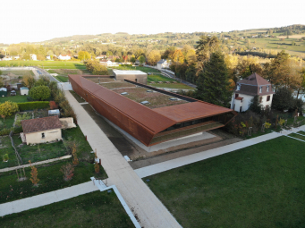 Le bardage en Corten se retourne en pour former une surtoiture. 