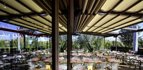La teinte rouille des profilés contraste avec la transparence et l’effet de miroir des parois vitrées.